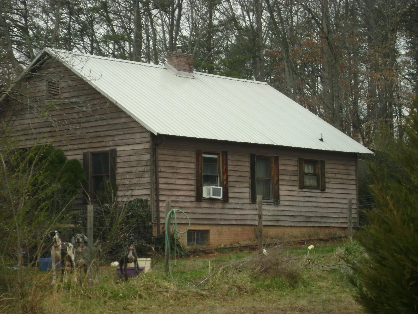 White metal roof on an old wood sided farmhouse, from a Metal Roof Installation job in Mamou